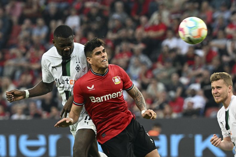 Piero Hincapié (izquierda), zaguero ecuatoriano del Bayer Leverkusen y Marcus Thuram del Borussia Monchengladbach durante el partido de la Bundesliga, el domingo 21 de mayo de 2023, en Leverkusen. (Federico Gambarini/dpa vía AP)