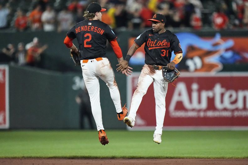 Gunnar Henderson (2) y Cedric Mullins (31) celebran la victoria de los Orioles de Baltimore ante los Azulejos de Toronto, el lunes 28 de julio de 2025, en Baltimore. (AP Foto/Stephanie Scarbrough)