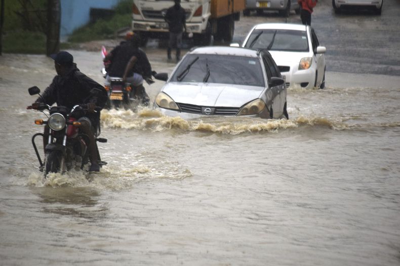 ARCHIVO - Motociclistas y automovilistas avanzan por una calle inundada en la ciudad keniana de Mombasa el viernes 3 de noviembre de 2023, luego de un intenso aguacero. (AP Foto/Gideon Maundu, Archivo)
