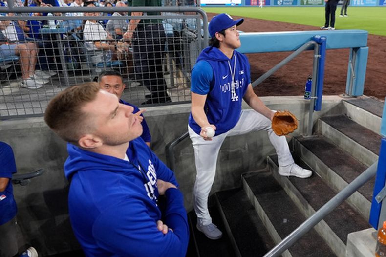 El pelotero de los Dodgers de Los Ángeles, Freddie Freeman (izquierda), y Shohei Ohtani observan desde la cueva durante la primera entrada de un partido de béisbol contra los Rojos de Cincinnati, el miércoles 9 de septiembre de 2026, en Los Ángeles. (Foto AP/Mark J. Terrill)