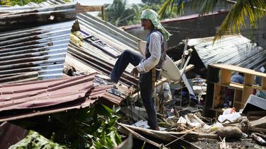Vecinos intentan recuperar pertenencias de sus casas dañadas tras un reciente alud de tierra provocado por la tormenta tropical Trami en Talisay, provincia de Batangas, Filipinas, que dejó a miles de personas sin hogar y varios muertos el sábado 26 de octubre de 2024. (AP Foto/Aaron Favila)