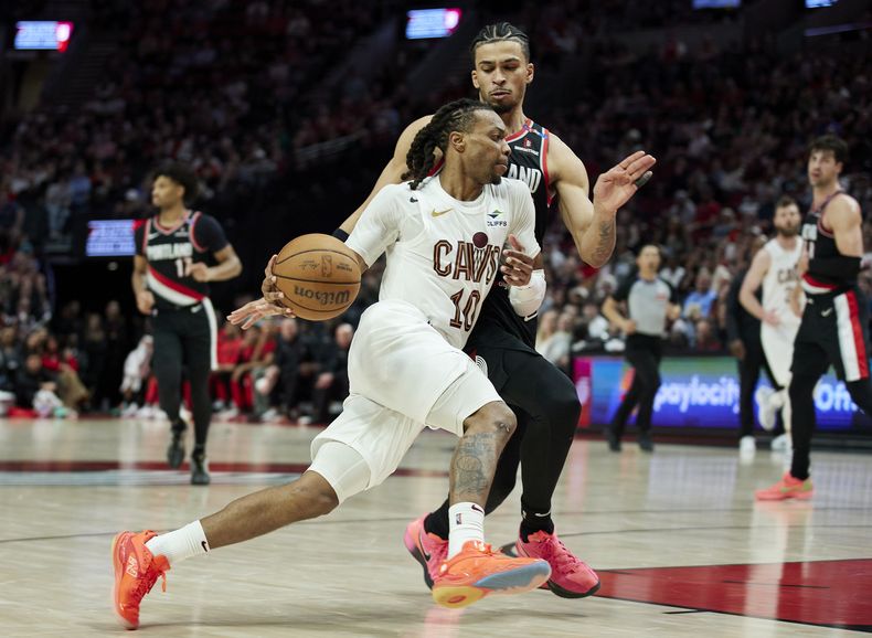Darius Garland, de los Cavaliers de Cleveland, dribla a Toumani Camara, de los Trail Blazers de Portland, en el partido del martes 25 de marzo de 2025 (AP Foto/Craig Mitchelldyer)