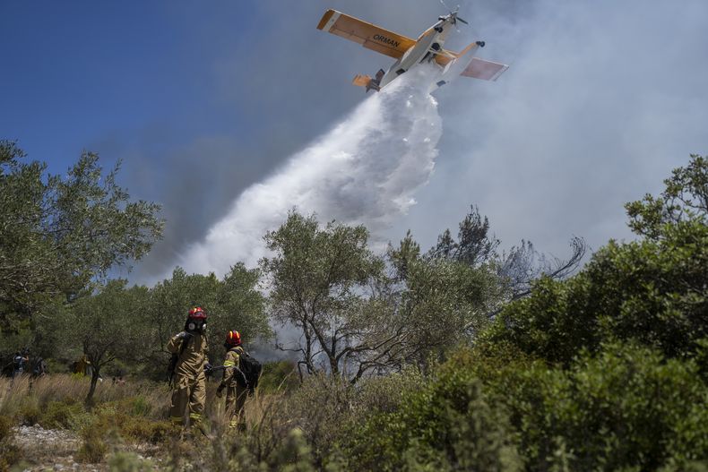 Un hidroavión arroja agua mientras los bomberos tratan de extinguir un incendio en la localidad de Vati, en la isla de Rodas, en el sureste de Grecia, el 25 de julio de 2023. (AP Foto/Petros Giannakouris)