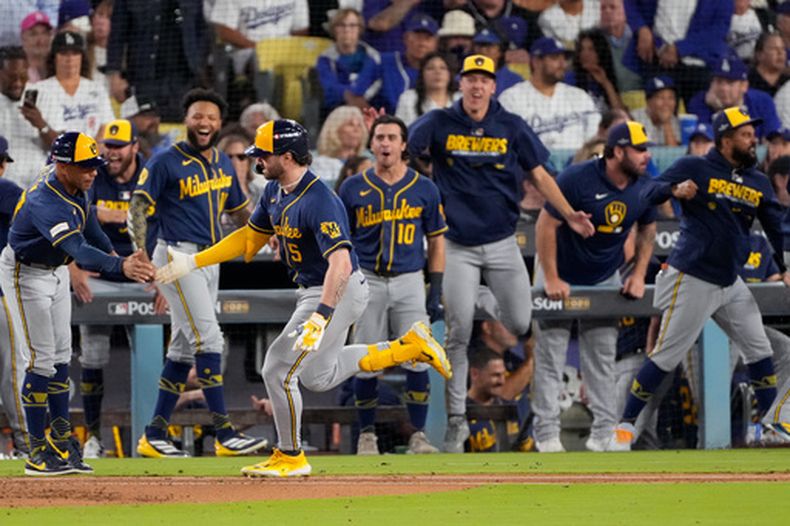 Garrett Mitchell (5), de los Cerveceros de Milwaukee corre y celebra al lado de sus compañeros después de batear un cuadrangular solitario durante la séptima entrada del Juego 3 de la Serie de Campeonato de la Liga Nacional frente a los Dodgers de Los Ángeles, el miércoles 14 de octubre de 2026, en Los Ángeles. (AP Foto/Mark J. Terrill)