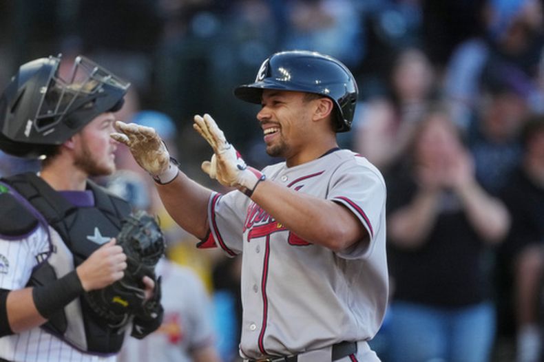 Drake Baldwin, de los Bravos de Atlanta (a la derecha), celebra mientras cruza el plato tras conectar un jonrón de dos carreras ante el lanzador abridor de los Rockies de Colorado, Brennan Bernardino, en la primera entrada de un partido de béisbol el sábado 2 de mayo de 2026, en Denver. (AP Foto/David Zalubowski)