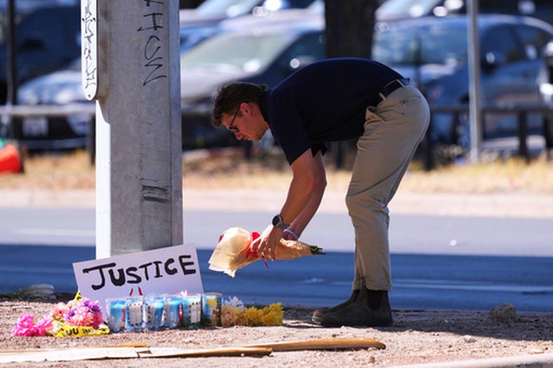 Un hombre coloca flores cerca del lugar donde un venezolano fue baleado por un agente del ICE el día anterior en Austin, Texas, lunes 21 de septiembre de 2026. (Foto AP/Eric Gay)