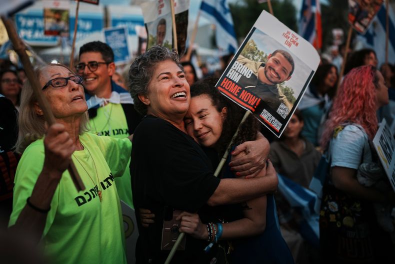 Gente reunida antes de la liberación de rehenes israelíes retenidos en Gaza, en una zona conocida como la Plaza de los Rehenes, en Tel Aviv, Israel, el lunes 13 de octubre de 2025. (AP Foto/Emilio Morenatti)