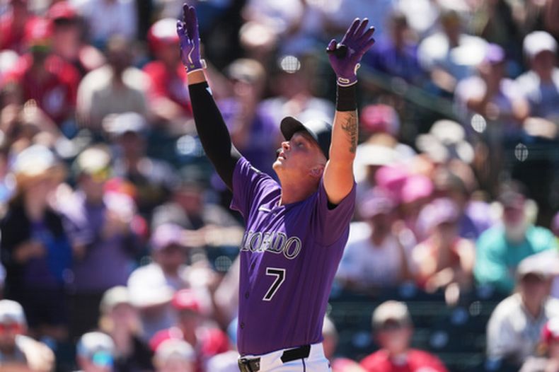 TJ Rumfield, de los Rockies de Colorado, hace un gesto al cruzar el plato tras conectar un jonrón de dos carreras ante el lanzador relevista de los Rojos de Cincinnati, Caleb Ferguson, en la sexta entrada de un partido de béisbol el sábado 18 de julio de 2026, en Denver. (Foto AP/David Zalubowski)