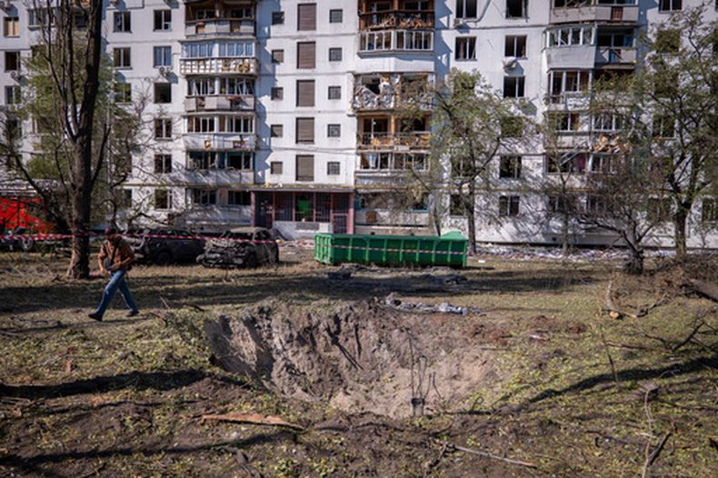 El cráter causado por un misil, delante de un edificio dañado por un ataque aéreo ruso, en Kiev, Ucrania, el 17 de septiembre de 2026. (AP Foto/Dan Bashakov)