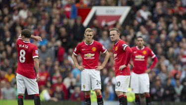 americateve | Los jugadores de Manchester United, entre ellos el capit&aacute;n Wayne Rooney, segundo desde la derecha, aguardan para reanudar el partido tras un gol de Swansea en su derrota 2-1 el s&aacute;bado, 16 de agosto de 2014, en Old Trafford. (AP Photo/Jon Sup
