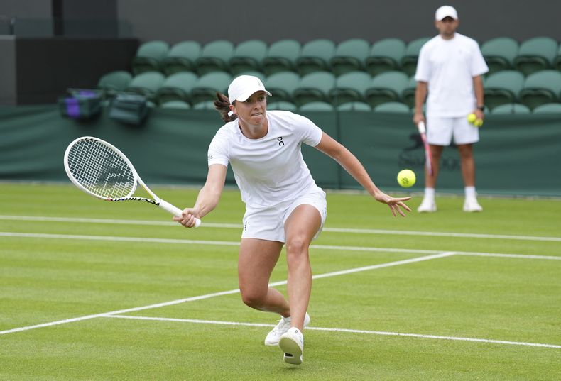 La polaca Iga Swiatek juega una volea en un entrenamiento en el England Lawn Tennis and Croquet Club ahead antes del inicio de Wimbledon el viernes 28 de junio del 2024.(Zac Goodwin/PA via AP)