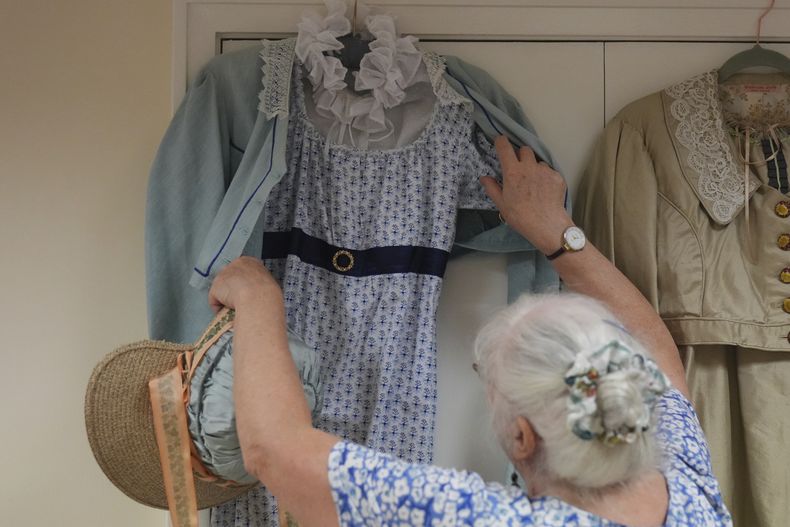 Kate Lobb, miembro de los Hampshire Regency Dancers y sastre, muestra un traje de la época de la regencia que confeccionó durante una sesión de práctica de baile de los Hampshire Regency Dancers en Winchester, Inglaterra, el 10 de septiembre de 2025. (Foto AP/Joanna Chan)