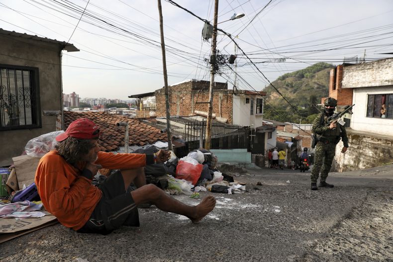 Un hombre se burla de un soldado que patrulla el barrio Siloé, en Cali, Colombia, el jueves 11 de septiembre de 2025. (AP Foto/Santiago Saldarriaga)