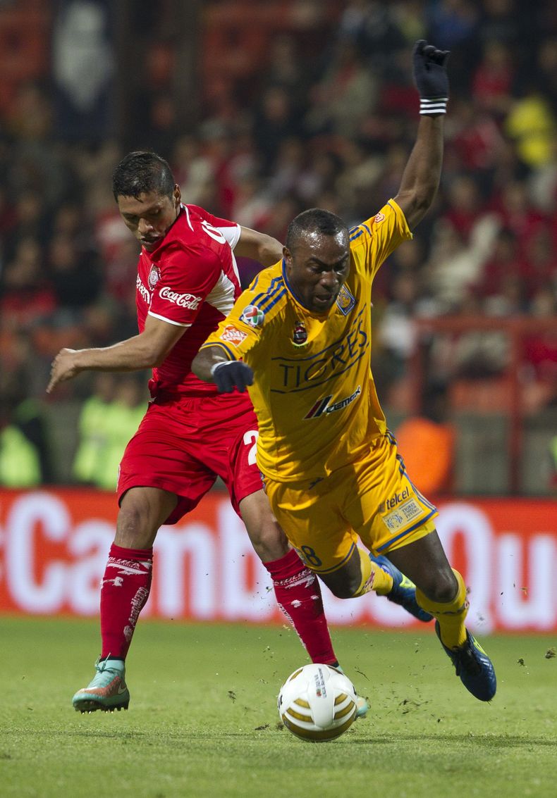 Richard Ortiz del Toluca, a la izquierda, disputa un bal&oacute;n con Joffre Guerr&oacute;n del Toluca en las semifinales del torneo Apertura de M&eacute;xico, el jueves 4 de diciembre de 2014. (AP Foto/Christian Palma)