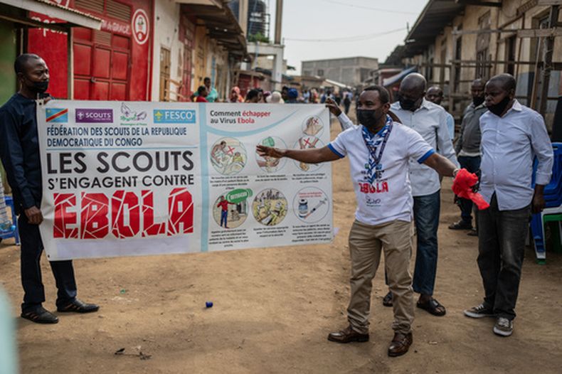 Miembros del movimiento de Scouts del Congo muestran una pancarta de concientización sobre el ébola en una calle durante una campaña de sensibilización del público en medio del brote de la enfermedad, en Bunia, República Democrática del Congo, el sábado 23 de mayo de 2026. (AP Foto/Moses Sawasawa)