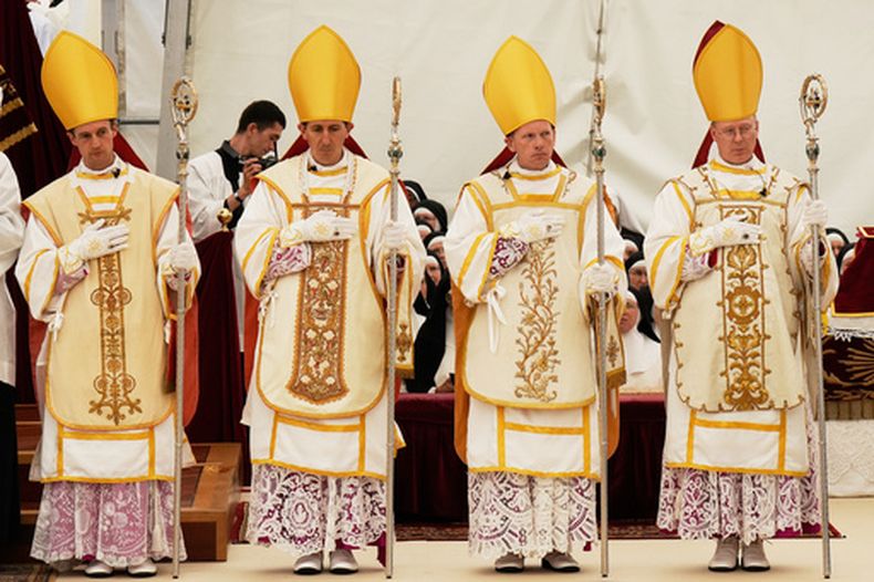 Los obispos recién consagrados (de izquierda a derecha) Marc Hanappier, Michel Poinsinet de Sivry, Michael Goldade y Pascal Schreiber, tocados con sus mitras y sosteniendo sus varas pastorales, al final de su ceremonia de consagración en una carpa instalada en el exterior del seminario de la Fraternidad de San Pío X, en Econe, Suiza, el 1 de julio de 2026. (AP Foto/Baz Ratner)