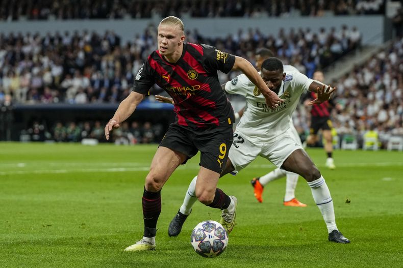 Erling Haaland (izquierda) del Manchester City pugna por el balón con Antonio Rudiger del Real Madrid en la semifinal de la Liga de Campeones, el martes 9 de mayo de 2023. (AP Foto/José Bretón)