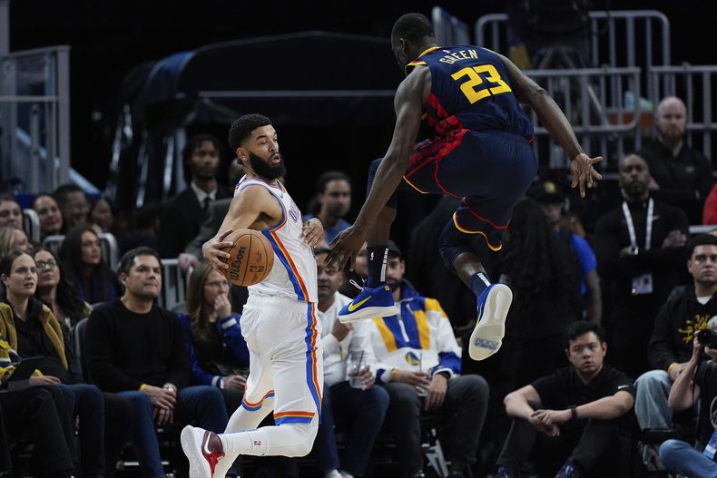 Kenrich Williams, del Thunder de Oklahoma City, elude a Draymond Green, de los Warriors de Golden State, el miércoles 27 de noviembre de 2024 (AP Foto/Godofredo A. Vásquez)