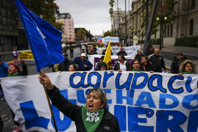 La gente grita consignas antigubernamentales durante una protesta contra la reforma previsional en Santiago, Chile, el domingo 30 de marzo de 2025. (Foto AP/Esteban Félix)