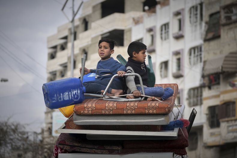 Dos niños se sientan sobre un colchón mientras montan en el auto familiar para huir de este a oeste de Ciudad de Gaza después de que el ejército israelí emitiera órdenes de evacuación en la zona, el viernes 11 de abril de 2025. (AP Foto/Jehad Alshrafi)