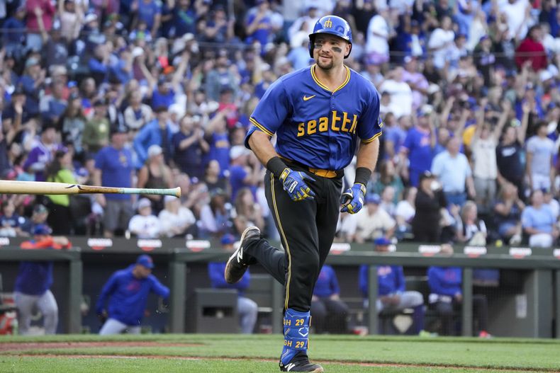 Cal Raleigh, de los Marineros de Seattle, lanza su bate y sonríe a sus compañeros de equipo tras conectar un jonrón durante la sexta entrada de un juego contra los Mets de Nueva York, el domingo 11 de agosto de 2024, en Seattle. (AP Foto/Liv Lyons)