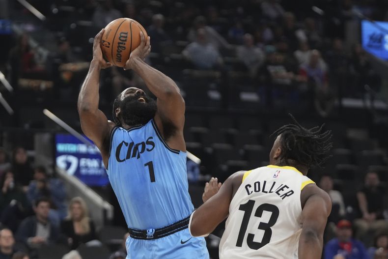 El escolta de los Clippers de Los Ángeles, James Harden, a la izquierda, dispara mientras el escolta del Jazz de Utah, Isaiah Collier, defiende durante la primera mitad, el domingo 17 de noviembre de 2024, en Inglewood, California (AP Foto/Mark J. Terrill)