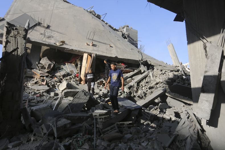 Palestinos caminan entre los restos de edificios destruidos en bombardeos israelíes sobre la Franja de Gaza, en Rafah, el 7 de noviembre de 2023. (AP Foto/Hatem Ali)