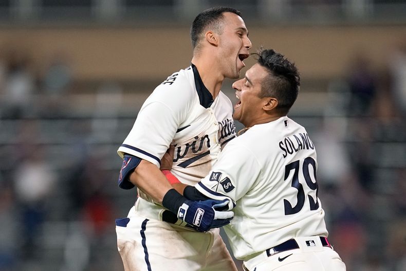 Alex Kirilloff, de los Mellizos de Minnesota, festeja con el colombiano Donovan Solano, luego de conectar el hit de la victoria sobre los Padres de San Diego, el miércoles 10 de mayo de 2023 (AP Foto/Abbie Parr)