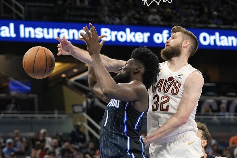 El alero del Magic de Orlando Jonathan Isaac, a la izquierda, y el alero de los Cavaliers de Cleveland Dean Wade (32) buscan un rebote durante la segunda mitad de un partido de baloncesto de la NBA, el martes 25 de febrero de 2025, en Orlando, Florida (AP Foto/John Raoux)