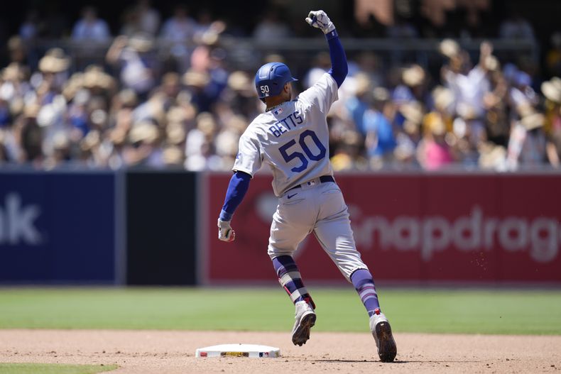 Mookie Betts de los Dodgers de Los Ángeles celebra mientras recorre las bases luego de conectar un grand slam en el cuarto episodio del juego ante los Padres de San Diego, en San Diego. Lunes 7 de agosto de 2023. (AP Foto/Gregory Bull)
