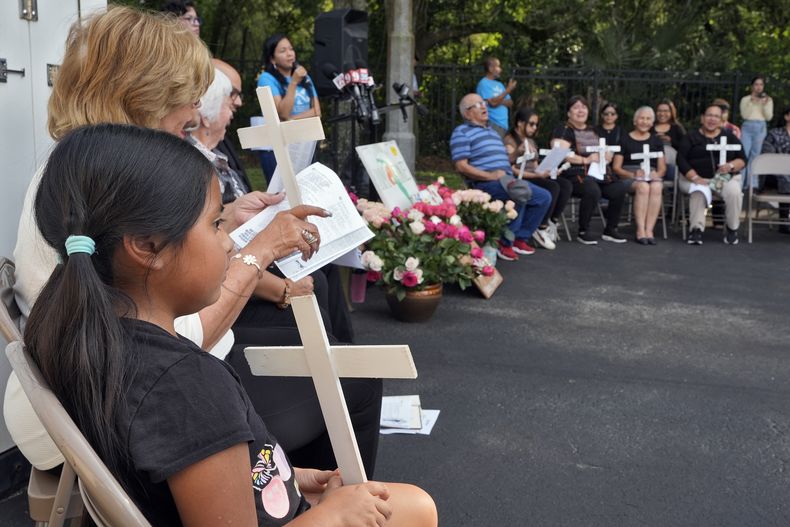 Personas oran durante una ceremonia conmemorativa en la Asociación de Trabajadores Agrícolas el miércoles 15 de mayo de 2024 en Apopka, Florida. Ocho trabajadores del campo procedentes de México murieron y decenas más resultaron heridos cuando una camioneta chocó con el autobús en que viajaban el martes 14 de mayo en Dunnellon, Florida. (AP Foto/Chris OMeara)