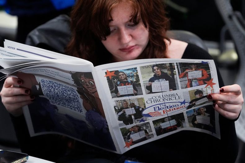 Kailey Ryan, una estudiante del Columbia College, lee un periódico en Chicago el 5 de noviembre del 2024. (AP foto/Nam Y. Huh)