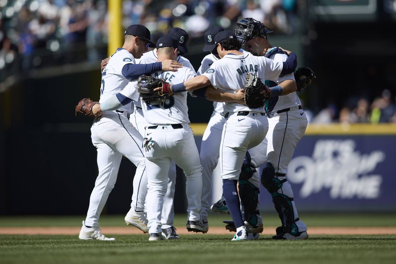Los Marineros de Seattle celebran una victoria por 5-1 sobre los Rojos de Cincinnati en un partido de béisbol el miércoles 17 de abril de 2024, en Seattle. (AP Foto/John Froschauer)