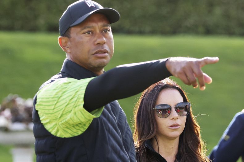 ARCHIVO - Tiger Woods y su novia Erica Herman permanecen en el green del 18vo hoyo durante el torneo JP McManus Pro-Am en Adare Manor, Limerick, Irlanda, el lunes 4 de julio de 2022. (AP Foto/Peter Morrison, Archivo)