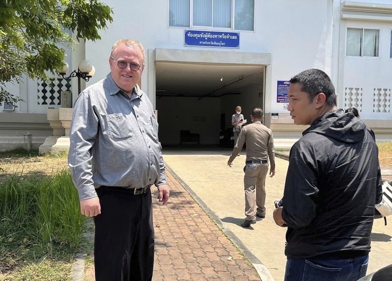 ARCHIVO - El profesor estadounidense de Ciencias Políticas Paul Chambers, izquierda, de la Universidad Naresuan tailandesa, permanece afuera de la etación de policía en Phitsanulok, Tailandia, donde fue arrestado bajo cargos de insultar a la monarquía. (AP Foto, archivo)