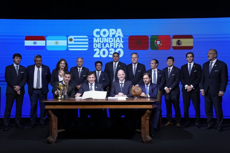 El presidente de Paraguay, Santiago Peña, sentado a la izquierda, junto al presidente de CONMEBOL, Alejandro Domínguez; el presidente de FIFA, Gianni Infantino; y el presidente de Uruguay, Luis Lacalle Pou, a la derecha, posan junto a dirigentes del fútbol sudamericano durante la ceremonia de apertura del 78° congreso de CONMEBOL en Luque, Paraguay, jueves, 11 abril, 2024. (AP Foto/Jorge Saenz)