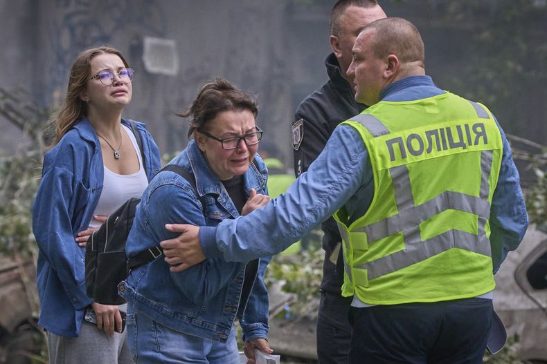 Mujeres reaccionan en el exterior de un edificio residencial destrozado en un ataque con misiles rusos, en Kiev, Ucrania, el 31 de julio de 2025. (AP Foto/Efrem Lukatsky)