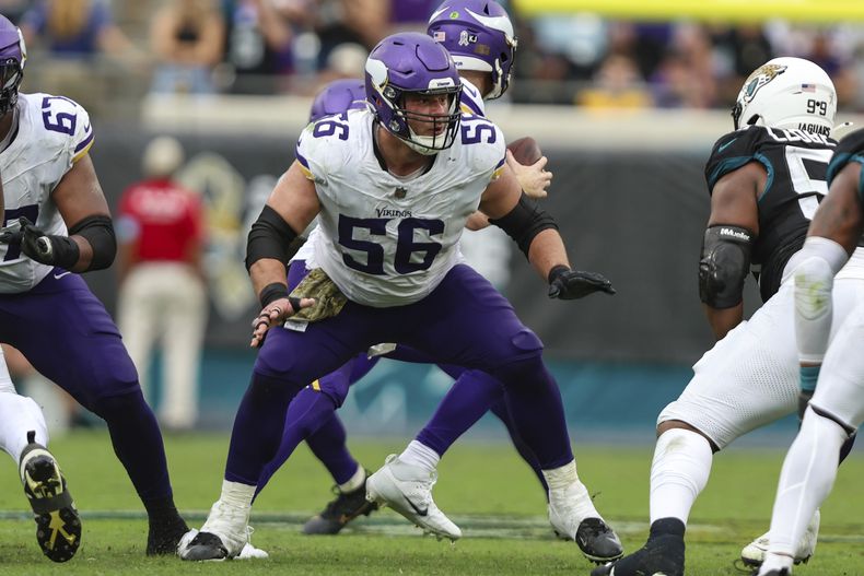 ARCHIVO - Garrett Bradbury (56), centro de los Vikings de Minnesota, se alista para bloquear durante un partido de la NFL en contra de los Jaguars de Jacksonville, el 10 de noviembre de 2024, en Jacksonville, Florida. (AP Foto/Gary McCullough, Archivo)