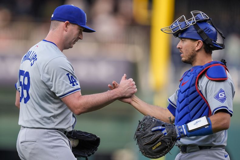 El lanzador de los Dodgers de Los Ángeles, Evan Phillips, a la izquierda, y el receptor Austin Barnes celebran la victoria del equipo en un juego de béisbol contra los Nacionales de Washington, en el Nationals Park, el jueves 25 de abril de 2024, en Washington. (AP Foto/Alex Brandon)