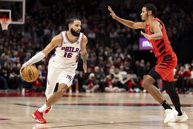 El alero de los 76ers de Filadelfia Caleb Martin avanza hacia la canasta intentando superar al alero de los Trail Blazers de Portland Toumani Camara el lunes 30 de diciembre del 2024. (AP Foto/Howard Lao)