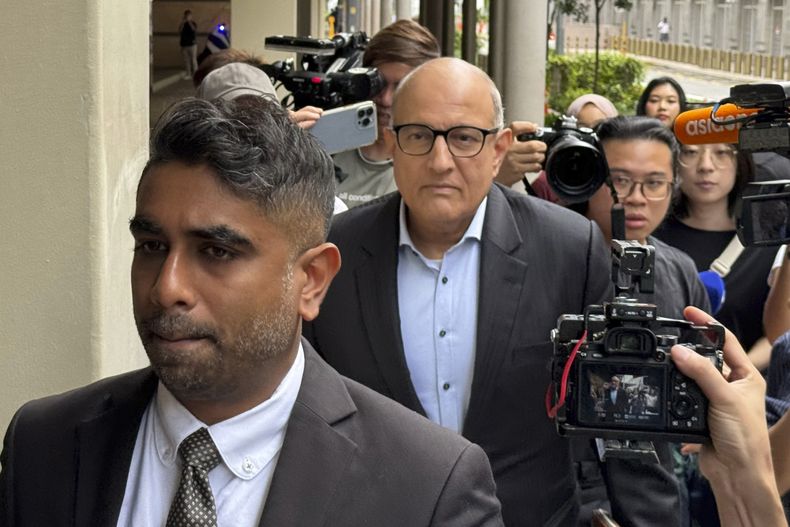 El exministro singapurense de Transporte, S. Iswaran (centro), y su abogado, Navin Thevar, a su llegada a la Corte Suprema en Singapur, el 5 de julio de 2024. (AP Foto)