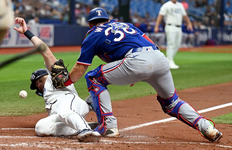 Hunter Feduccia de los Rays de Tampa Bay anota una carrera tras el sencillo de Yandy Díaz frente al receptor Austin Wynns (38) de los Rangers de Texas, el jueves 30 de julio de 2026, en St. Petersburg, Florida. (AP Foto/Jason Behnken)