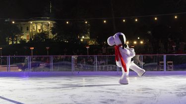 Con la Casa Blanca decorada para las festividades navideñas al fondo, Snoopy patina sobre la pista de hielo de la Casa Blanca, ubicada en el patio sur del complejo, el miércoles 29 de noviembre de 2023, durante la ceremonia de presentación de la pista en Washington. (AP Foto/Jacquelyn Martin)