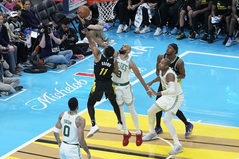 Bruce Brown (11), de los Pacers de Indiana, dispara ante el intento de bloqueo de Derrick White (9), de los Celtics de Boston, durante la segunda mitad del juego del torneo In-Season, el lunes 4 de diciembre de 2023, en Indianápolis. (AP Foto/Darron Cummings)