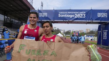 Los mexicanos Emiliano Hernández (derecha) y Duilio Carrillo muestran un cartel de apoyo a Acapulco tras ganar la medalla de oro de los relevos masculinos del pentatlón moderno de los Juegos Panamericanos en Santiago, Chile, el viernes 27 de octubre de 2023. (AP Foto/Matías Delacroix)