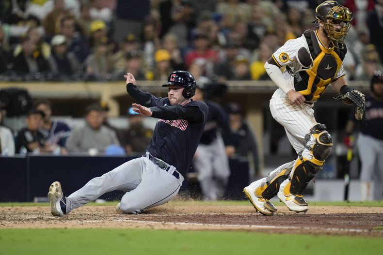 David Fry, de los Guardianes de Cleveland, se desliza para anotar ante los Padres de San Diego, el jueves 15 de junio de 2023 (AP Foto/Gregory Bull)