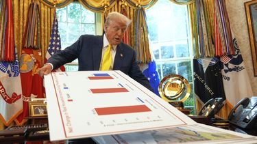 ARCHIVO – El presidente estadounidense Donald Trump muestra gráficos mientras habla sobre la economía en la Oficina Oval de la Casa Blanca, el 7 de agosto de 2025, en Washington. (AP Foto/Mark Schiefelbein, Archivo)