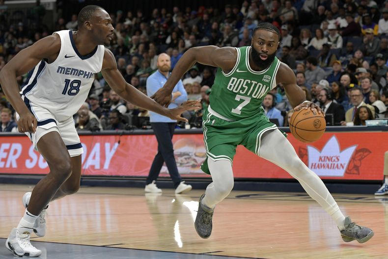 Jaylen Brown (7), de los Celtics de Boston, conduce el balón en contra de Bismack Biyombo (18), de los Grizzlies de Memphis, en la segunda mitad del juego de baloncesto de la NBA, el domingo 19 de noviembre de 2023, en Memphis, Tennessee. (AP Foto/Brandon Dill)
