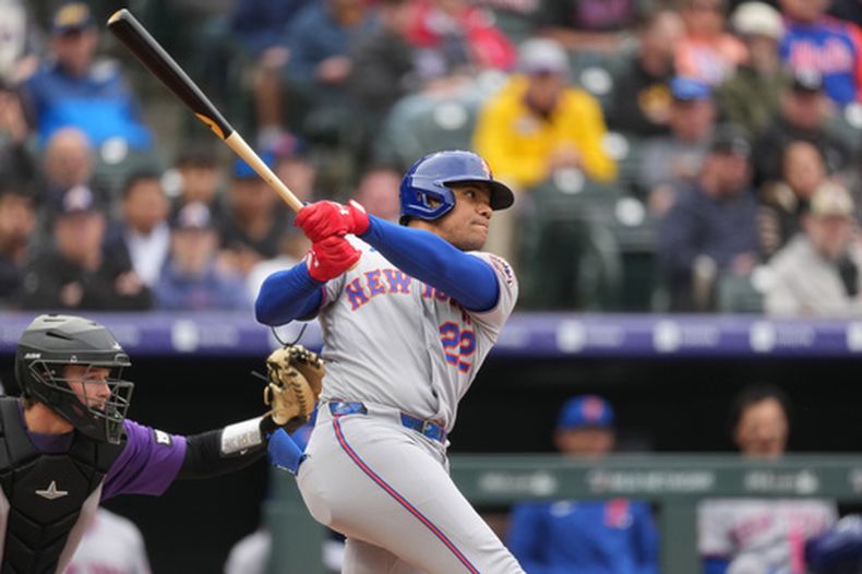Juan Soto (22), de los Mets de Nueva York, pega un elevado para out contra los Rockies de Colorado al abridor Tomoyuki Sugano, en la cuarta entrada del juego de béisbol de Grandes Ligas, el lunes 4 de mayo de 2026, en Denver. (AP Foto/David Zalubowski)