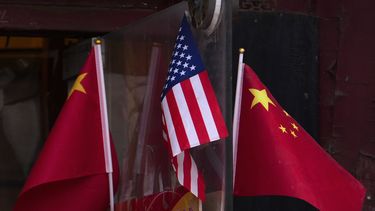 Banderas de China y Estados Unidos ondean afuera de una tienda de recuerdos el 31 de enero de 2025, en Beijing. (AP Foto/Andy Wong)